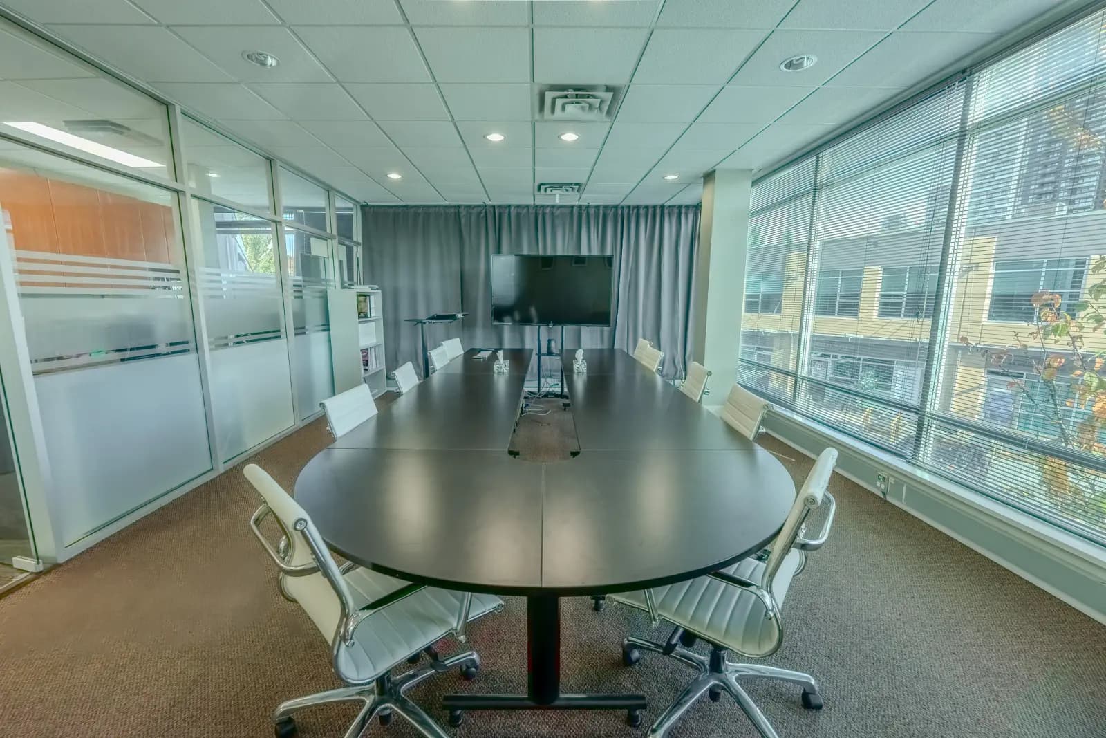 Seminar room table set for a group, facing the presentation screen